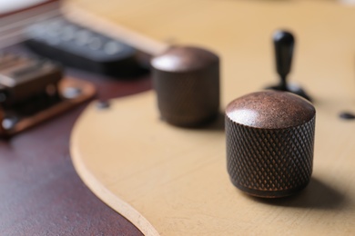 Photo of Closeup view of electric guitar, focus on volume controls