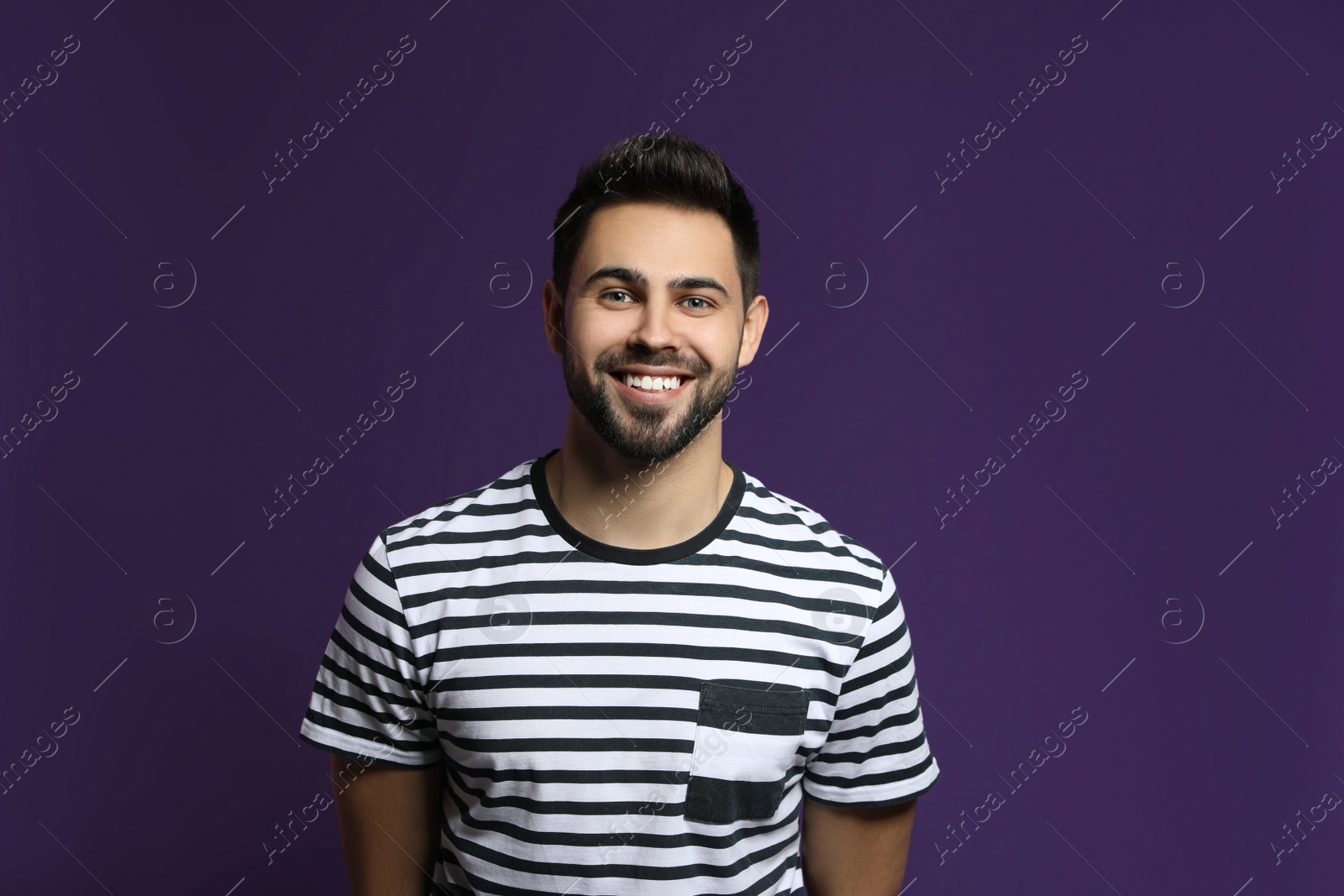 Photo of Young man laughing on purple background. Funny joke