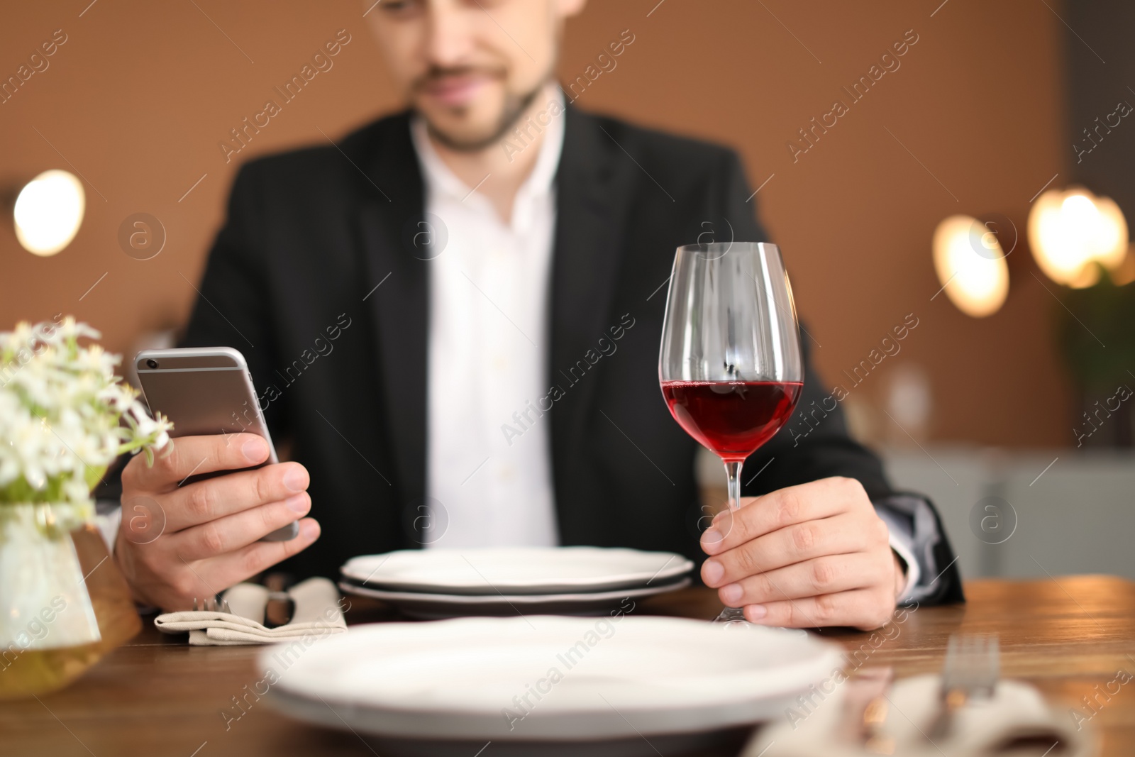 Photo of Man with glass of wine at table in restaurant