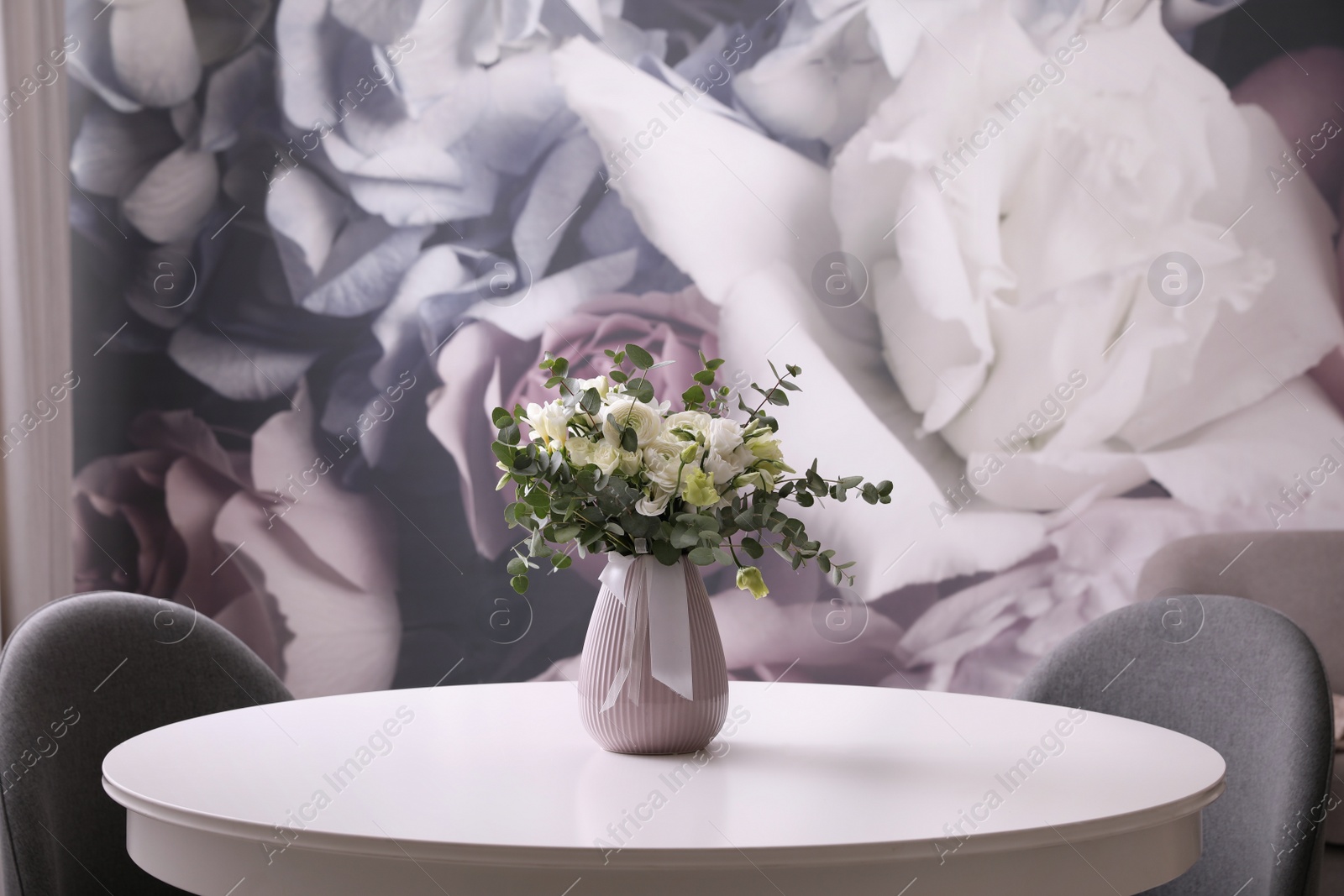 Photo of Vase with beautiful bouquet on white table indoors. Stylish interior element