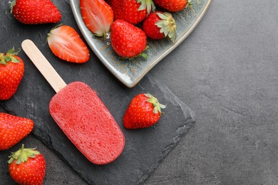 Photo of Tasty fruit ice pop with strawberries on dark table, flat lay. Space for text