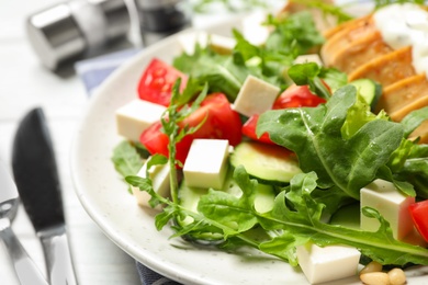 Photo of Delicious salad with chicken, arugula and tomatoes on plate, closeup