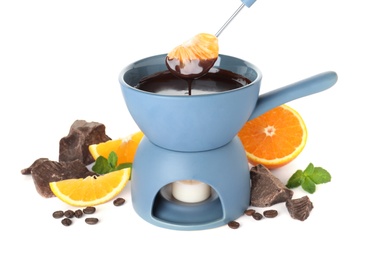 Fondue pot with chocolate and fruits on white background