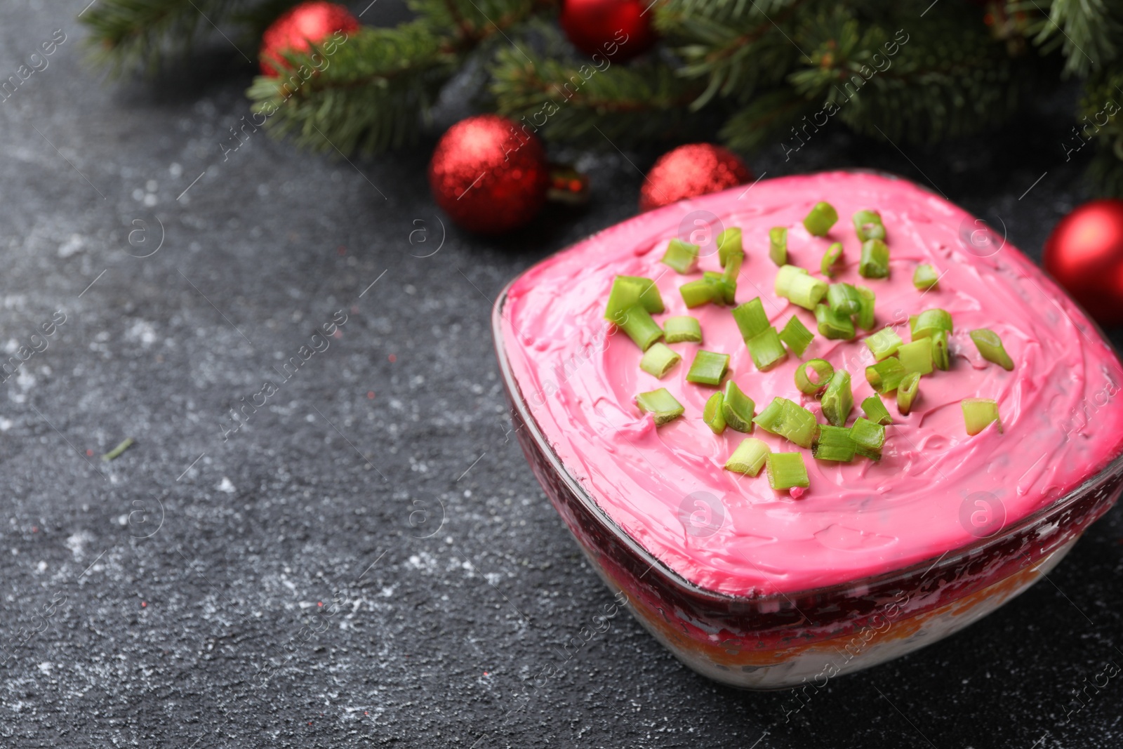 Photo of Herring under fur coat salad and Christmas decor on grey table, space for text. Traditional Russian dish