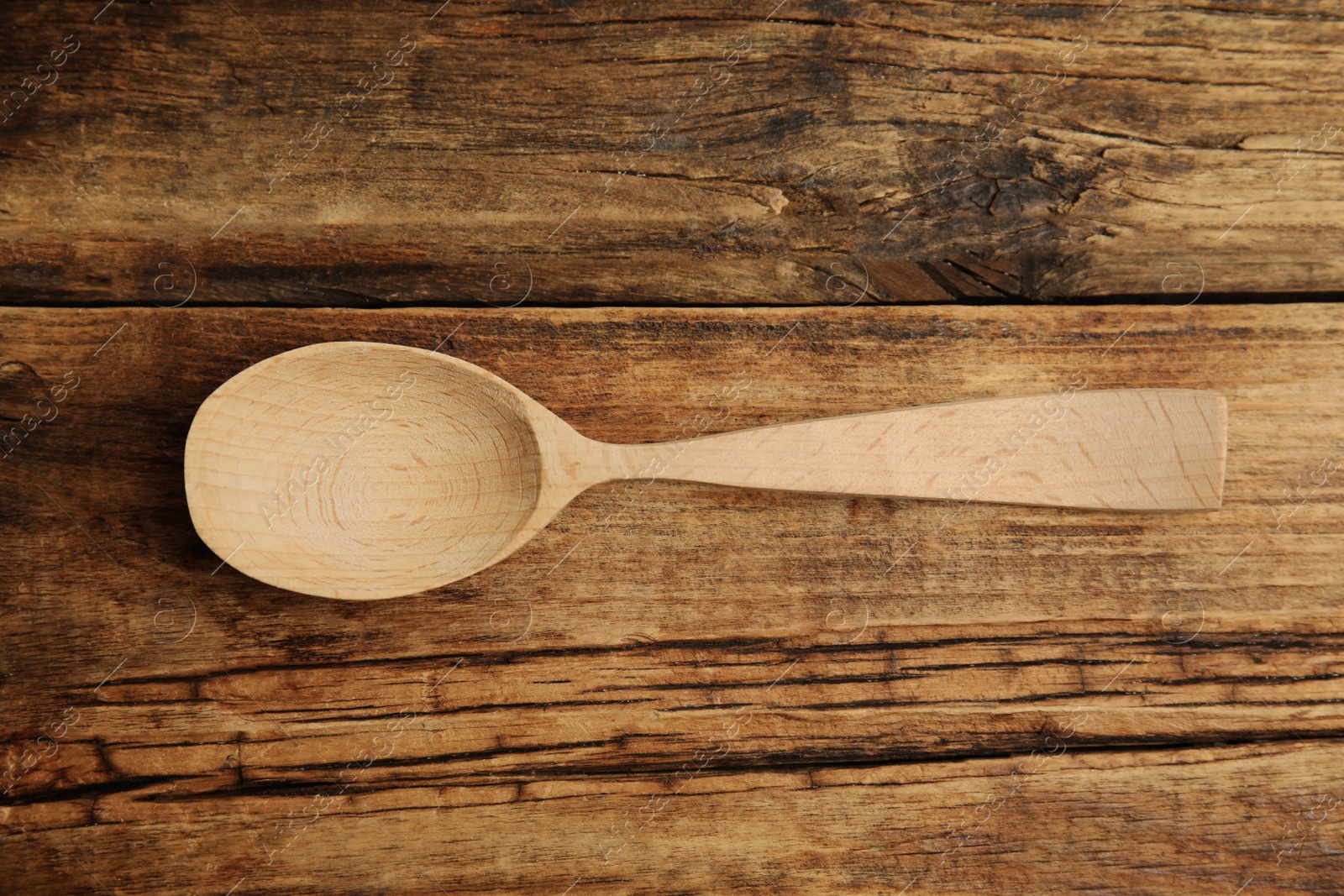 Photo of Handmade wooden spoon on rustic table, top view