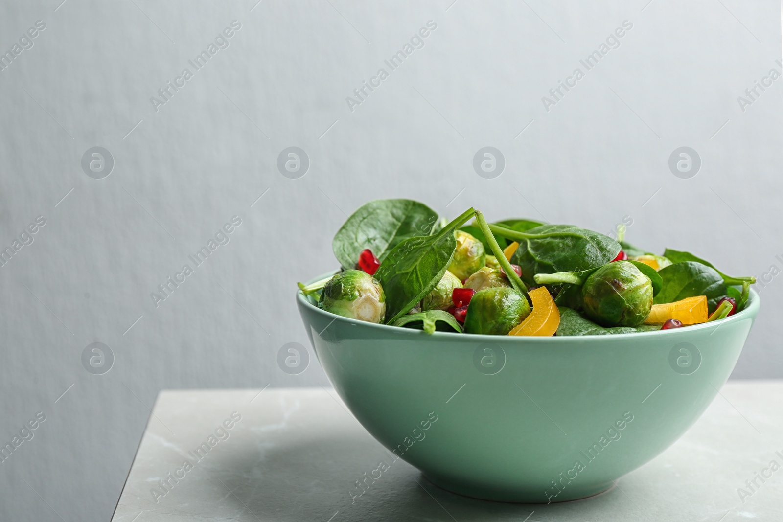 Photo of Tasty salad with Brussels sprouts on light grey table