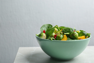 Tasty salad with Brussels sprouts on light grey table