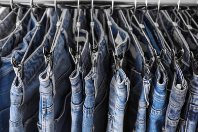 Photo of Closeup view of rack with different jeans