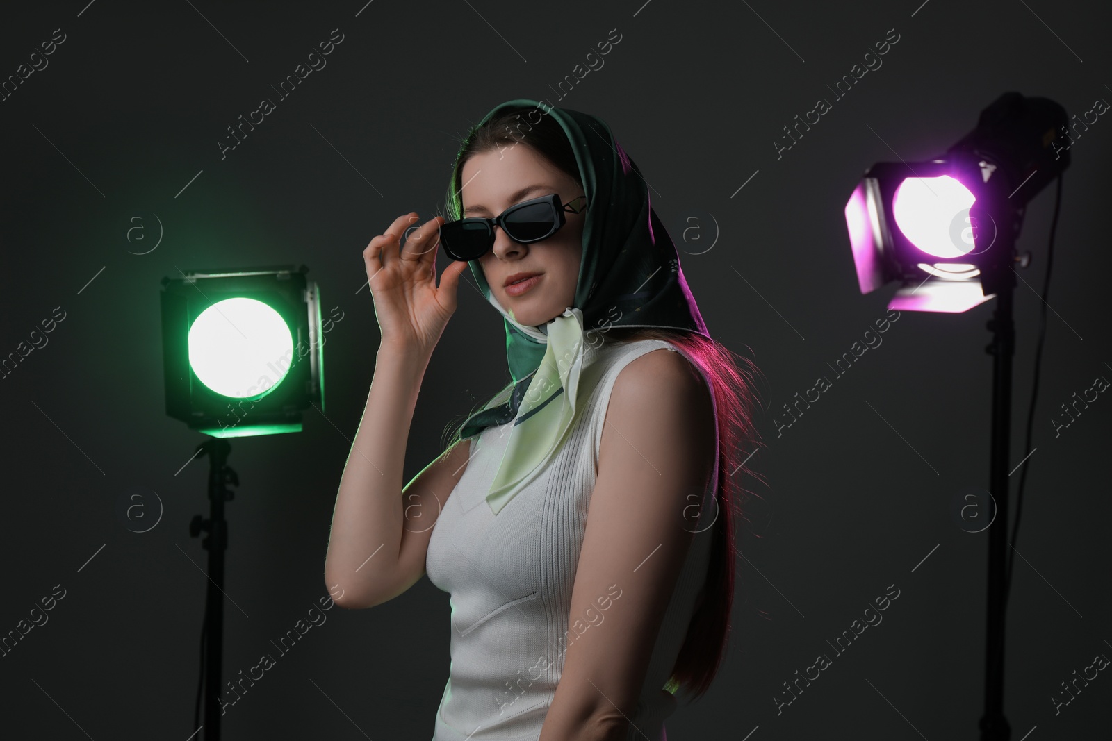 Photo of Portrait of beautiful young woman with sunglasses in photo studio