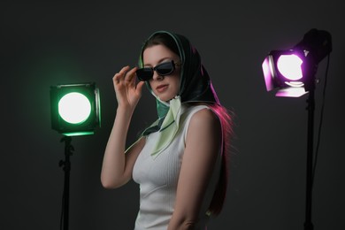 Portrait of beautiful young woman with sunglasses in photo studio