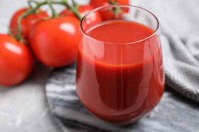 Photo of Delicious fresh tomato juice in glass on table, closeup