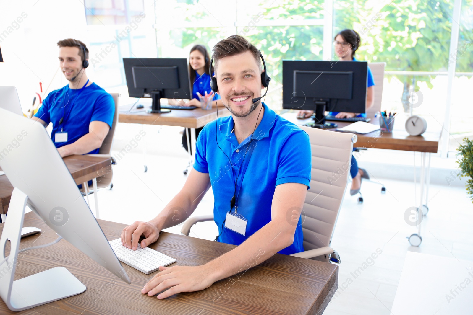 Photo of Male technical support operator with headset at workplace