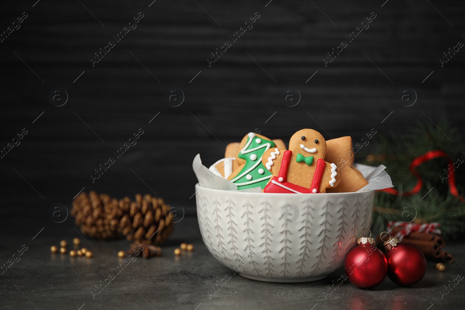 Photo of Tasty homemade Christmas cookies on grey table against dark background, space for text