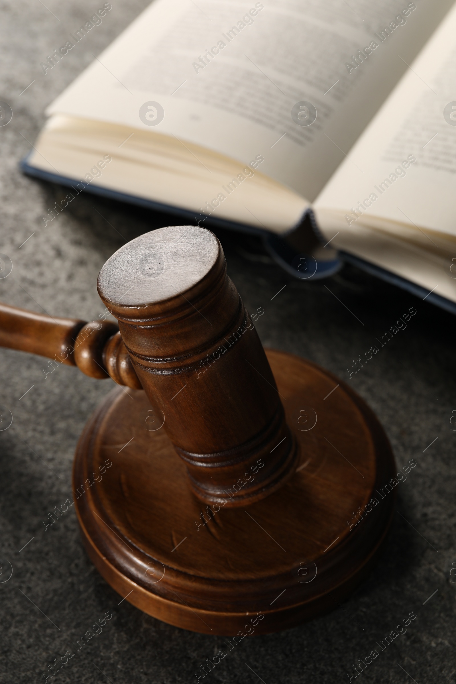 Photo of Law concept. Gavel and book on grey textured table, closeup