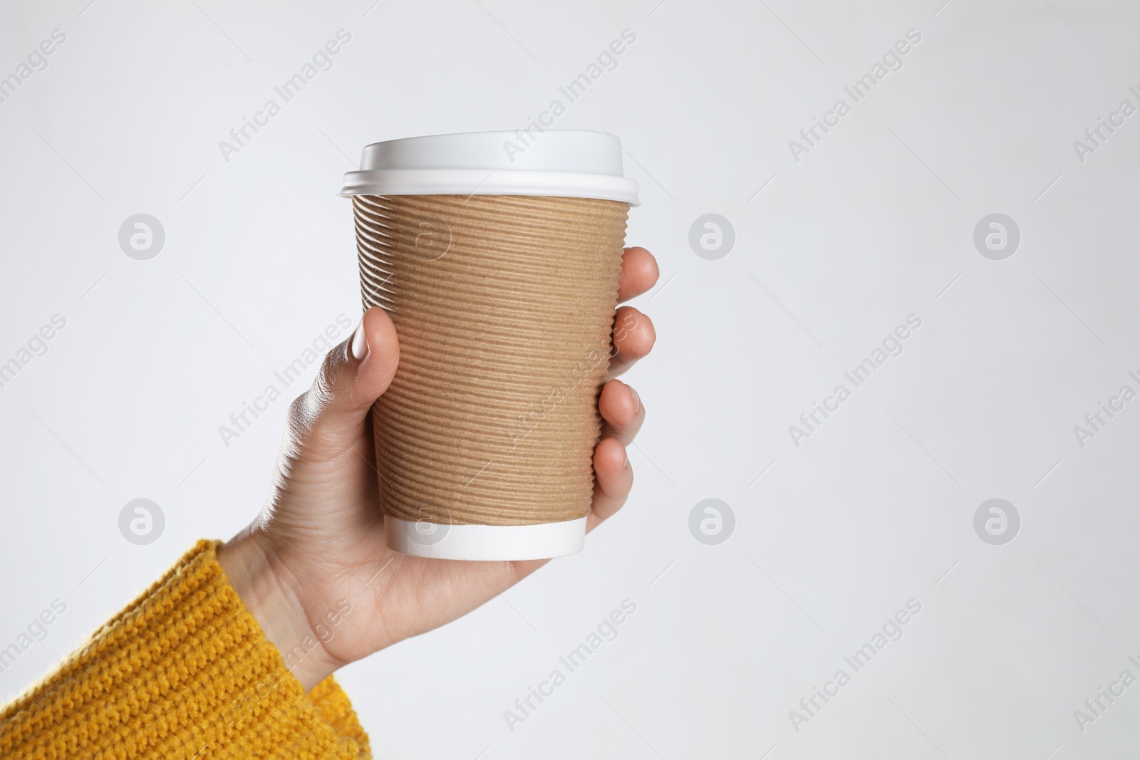 Photo of Woman holding takeaway paper coffee cup on white background, closeup