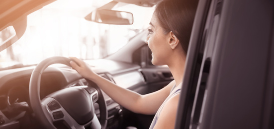 Image of Happy young woman driving modern car on sunny day. Banner design