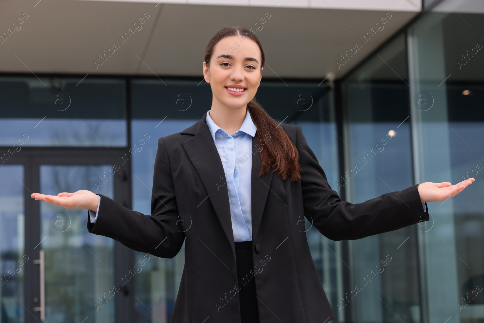 Photo of Happy real estate agent in suit outdoors