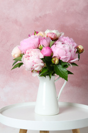 Photo of Bouquet of beautiful peonies in vase on white table