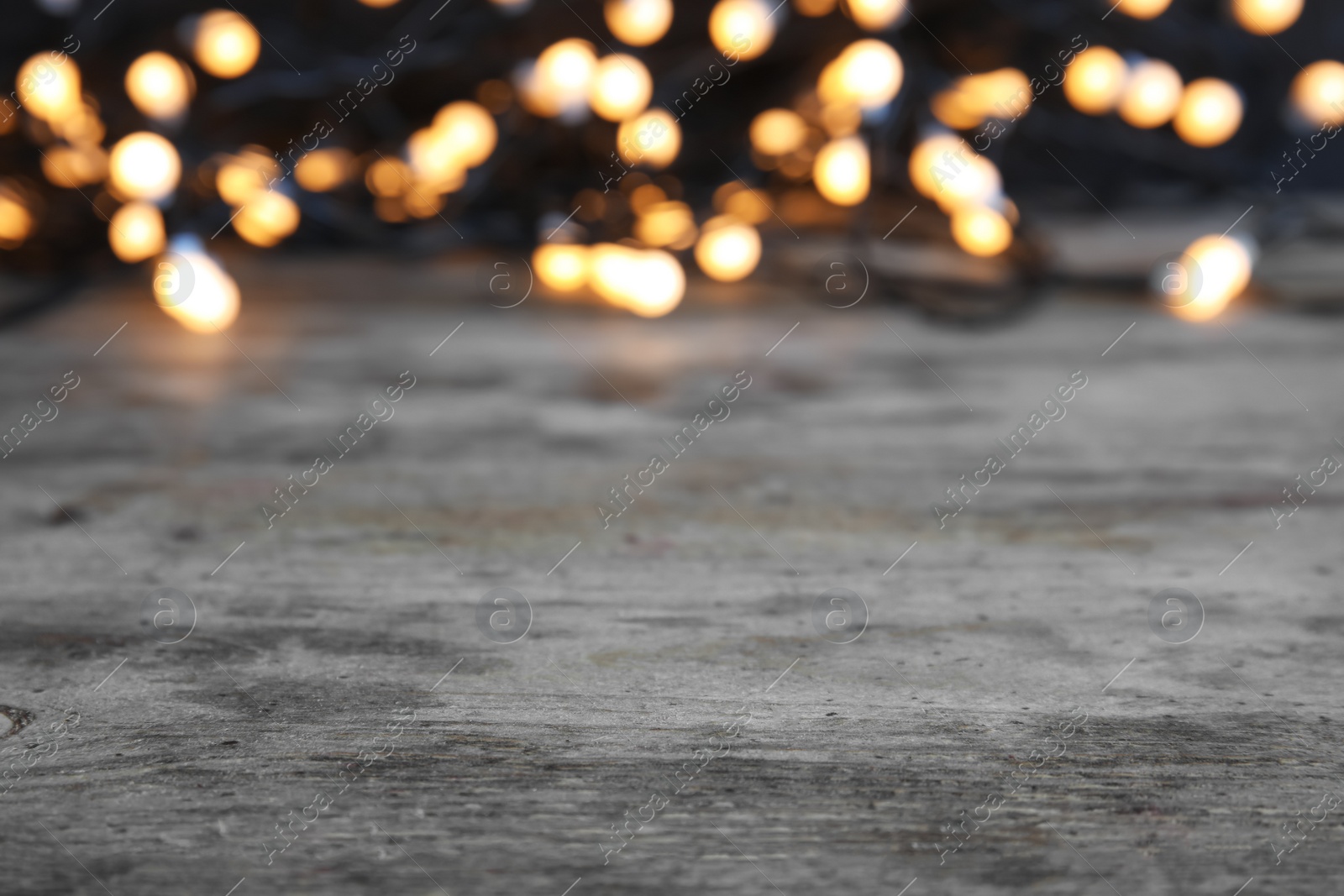 Photo of Wooden table and blurred Christmas lights on background