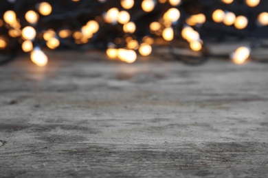 Wooden table and blurred Christmas lights on background