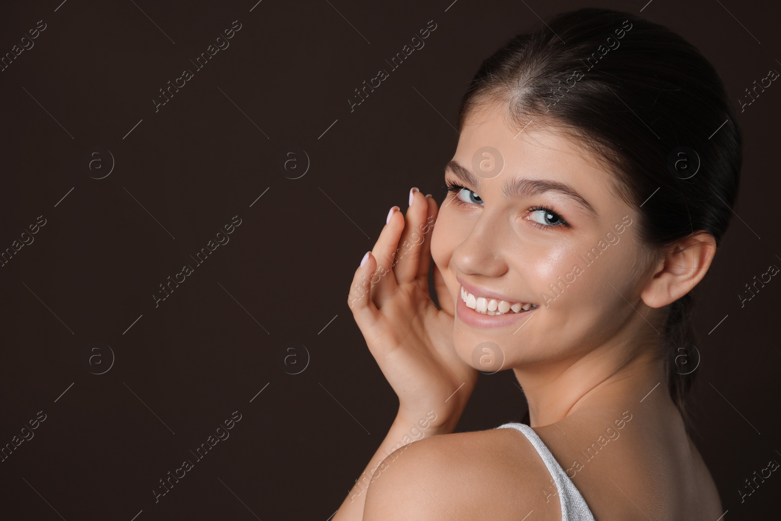 Photo of Portrait of pretty girl on brown background, space for text. Beautiful face with perfect smooth skin