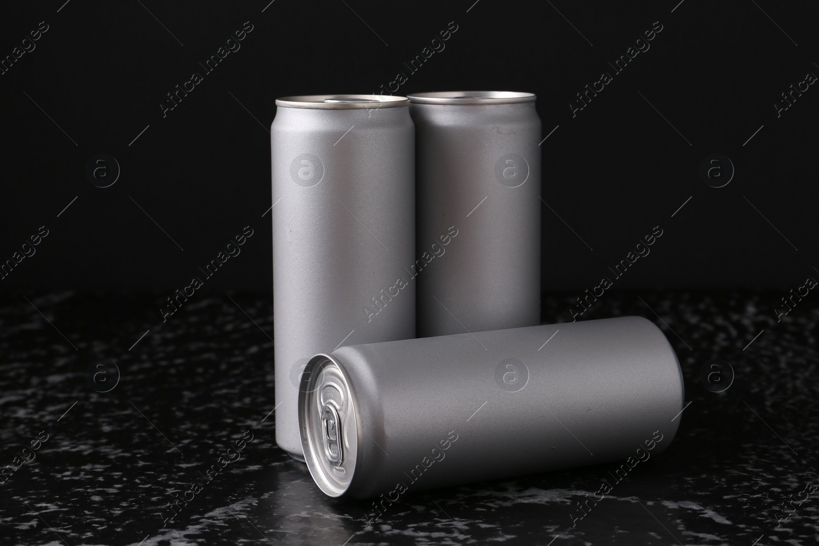 Photo of Energy drinks in cans on black textured table