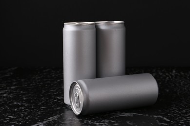 Energy drinks in cans on black textured table
