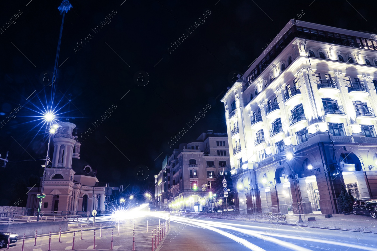 Photo of View of night cityscape with illuminated buildings and light trails