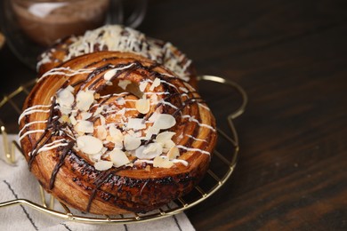 Sweet buns. Delicious rolls with toppings and almond on wooden table, closeup. Space for text