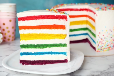 Photo of Delicious rainbow cake for party on table