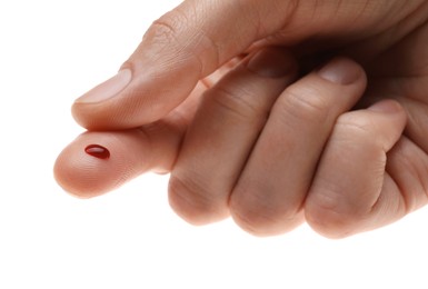 Photo of Woman with pricked finger and blood drop on white background, closeup