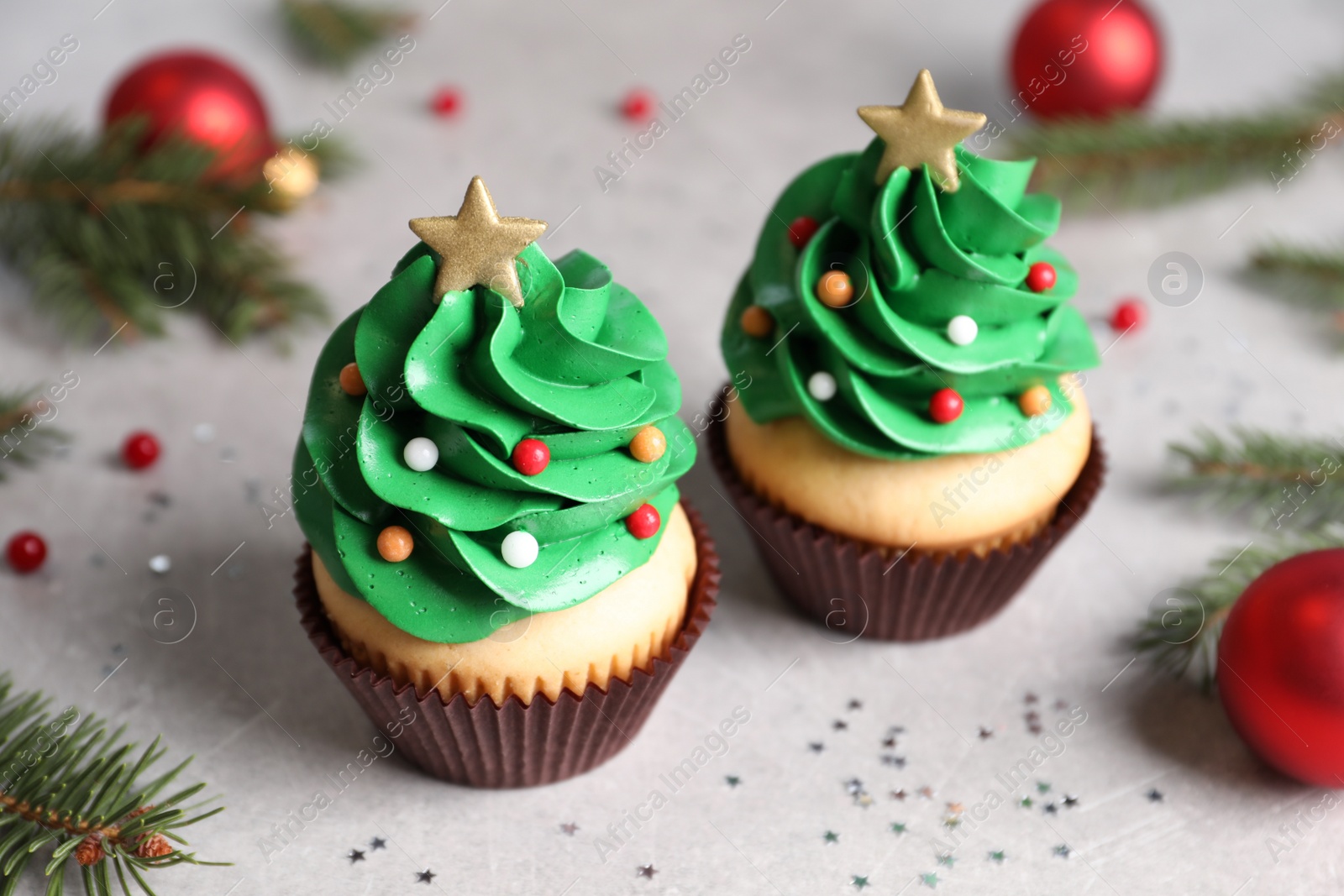 Photo of Christmas tree shaped cupcakes on light grey table