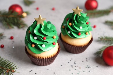 Christmas tree shaped cupcakes on light grey table