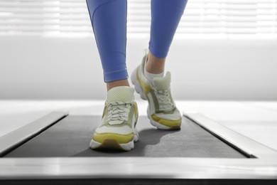 Photo of Woman training on walking treadmill at home, closeup