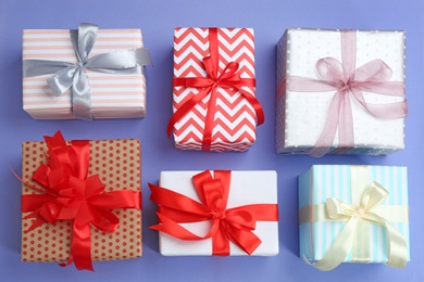 Photo of Beautifully decorated gift boxes on color background, top view