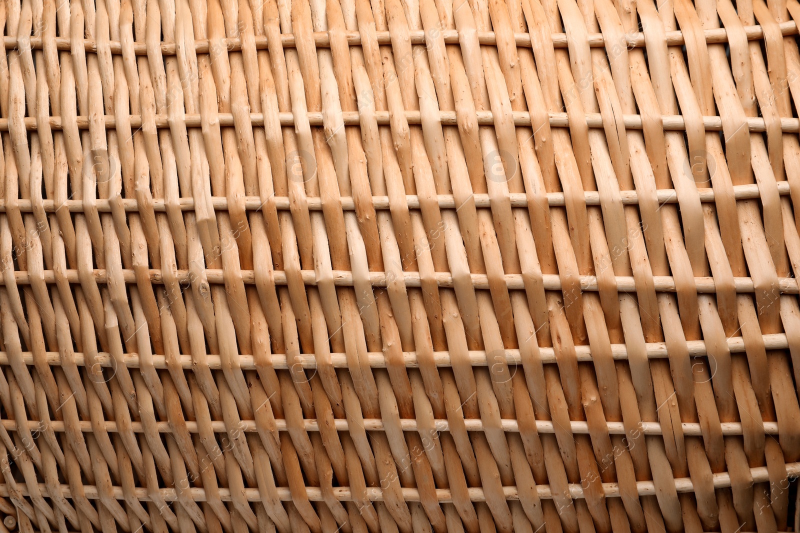 Photo of Handmade wicker basket made of natural material as background, closeup view