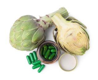 Photo of Fresh artichokes and bottle of pills isolated on white, top view