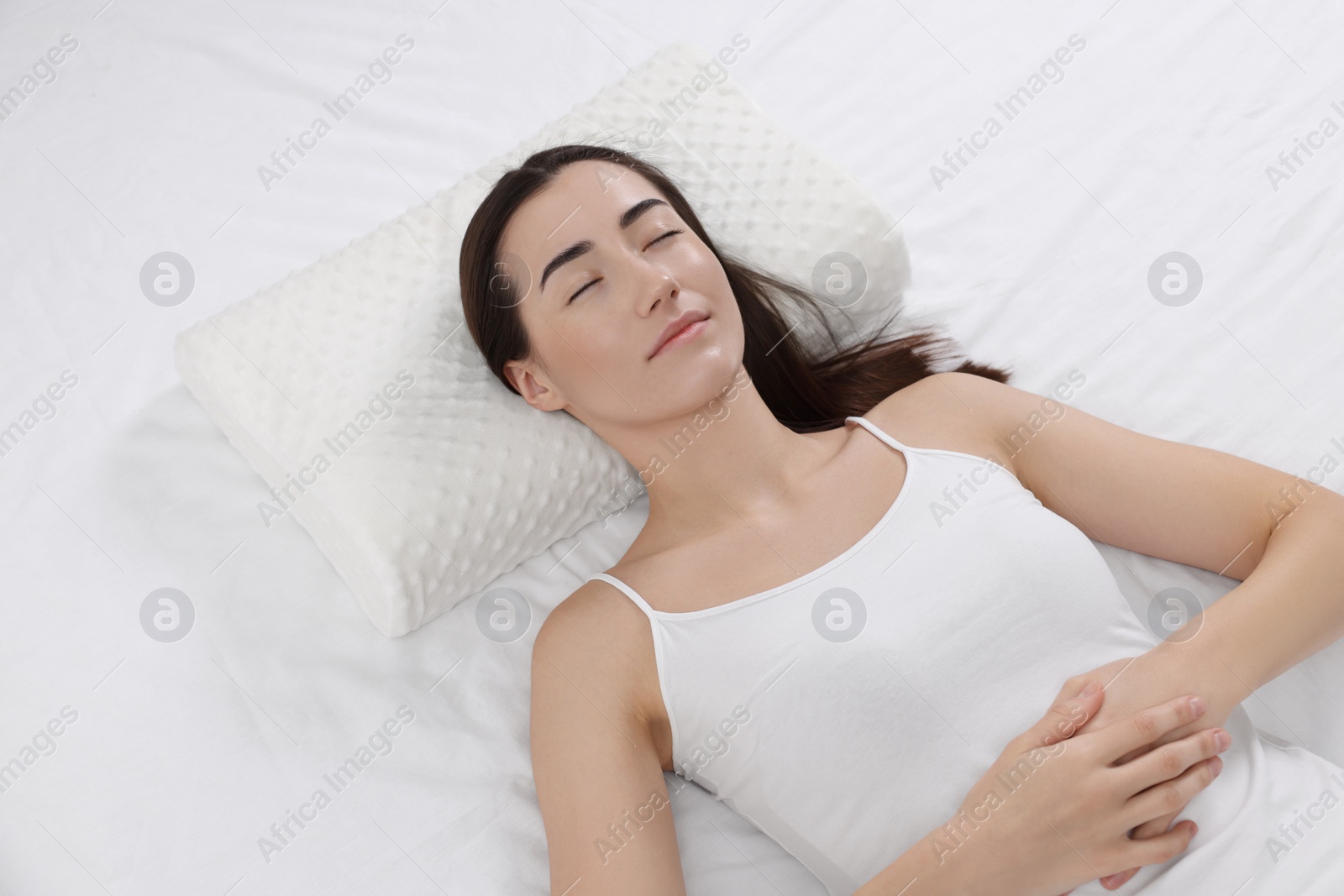 Photo of Woman sleeping on orthopedic pillow in bed