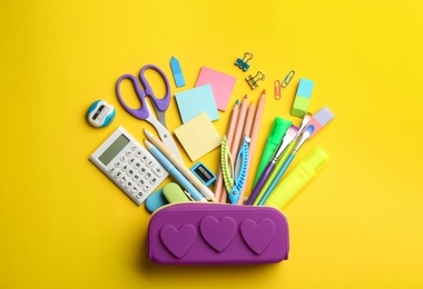 Photo of Flat lay composition with school stationery on yellow background. Back to school