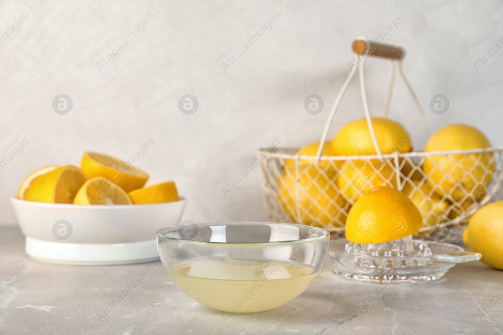 Photo of Composition with freshly squeezed lemon juice on table
