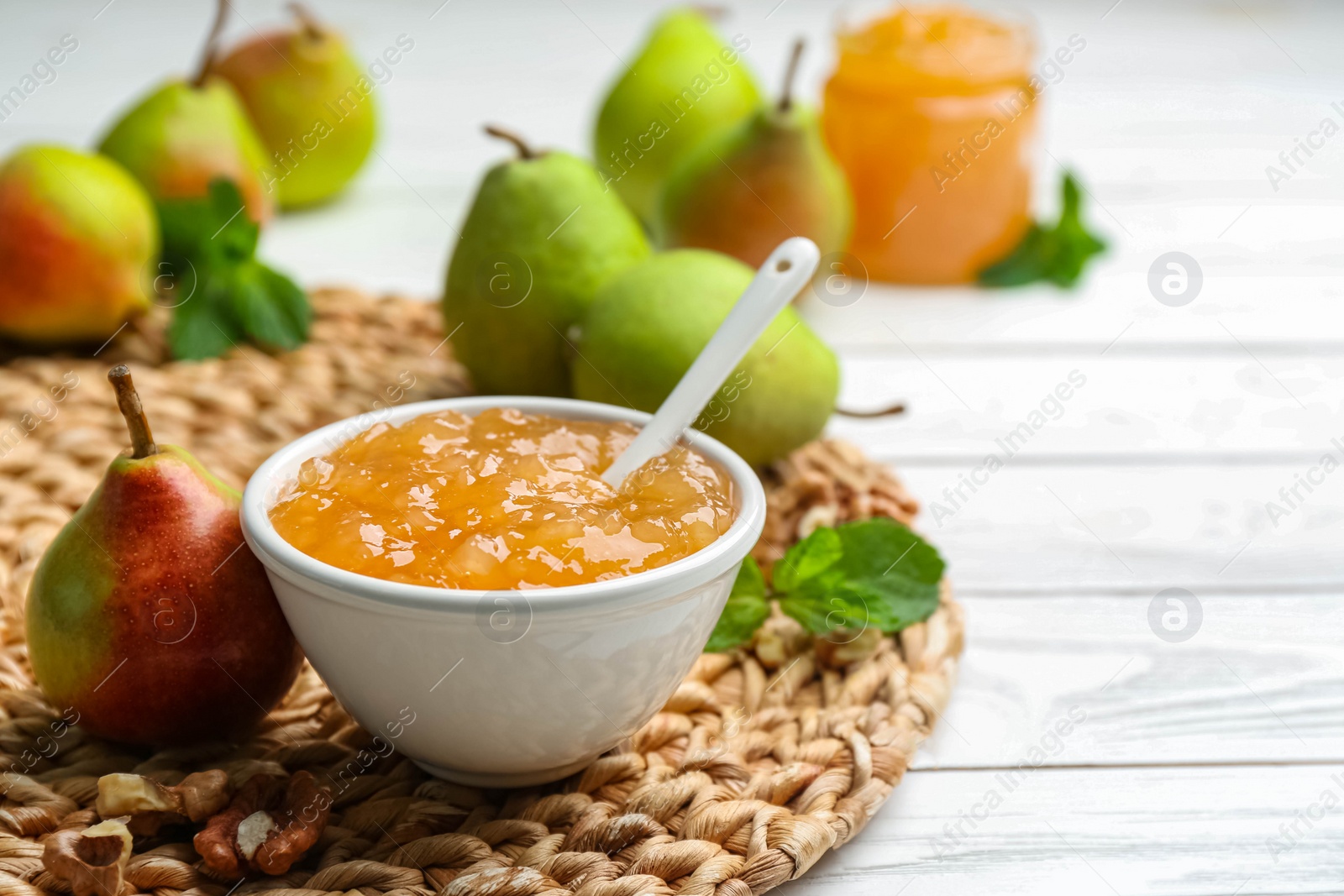 Photo of Delicious pear jam and fresh fruits on white wooden table. Space for text