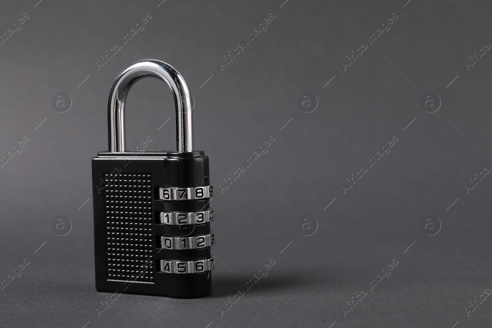 Photo of One steel combination padlock on dark grey background, closeup. Space for text