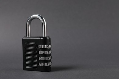 Photo of One steel combination padlock on dark grey background, closeup. Space for text