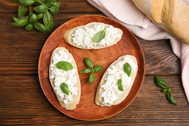 Photo of Bread with cottage cheese and basil on wooden table, flat lay