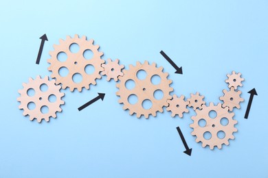 Photo of Business process organization and optimization. Scheme with wooden figures and arrows on light blue background, top view