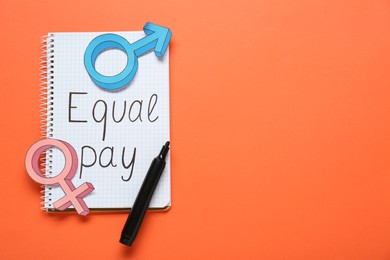 Photo of Equal pay. Notebook, paper gender symbols and marker on orange background, top view. Space for text