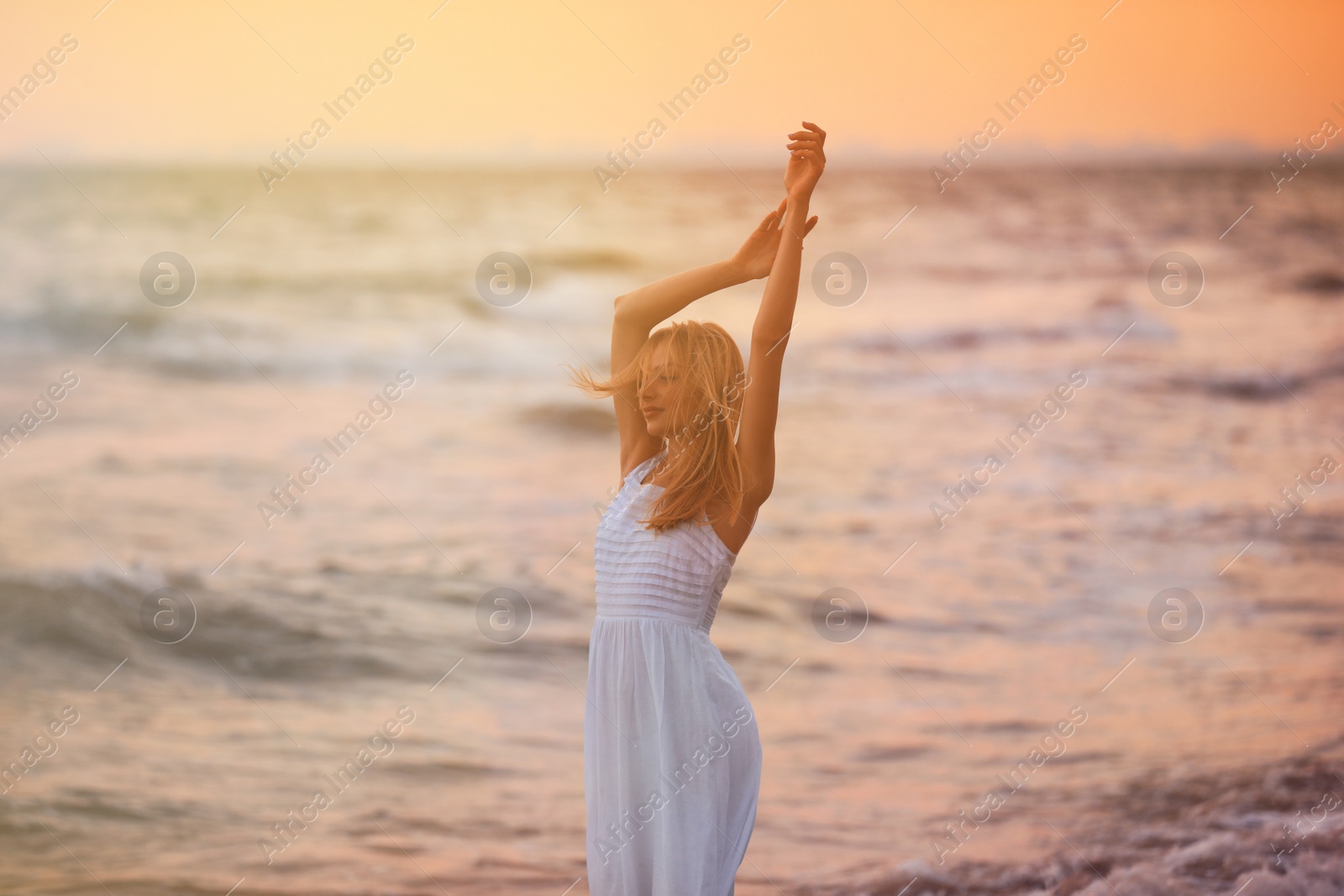 Photo of Beautiful young woman on beach at sunset