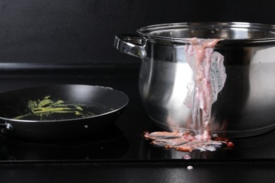 Dirty pot and frying pan on cooktop in kitchen, closeup