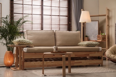 Living room interior with sofa, window blinds and stylish decor elements