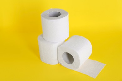 Photo of Many soft toilet paper rolls on yellow background